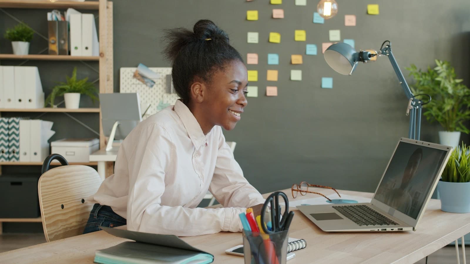 A smiling learner in front of her laptop